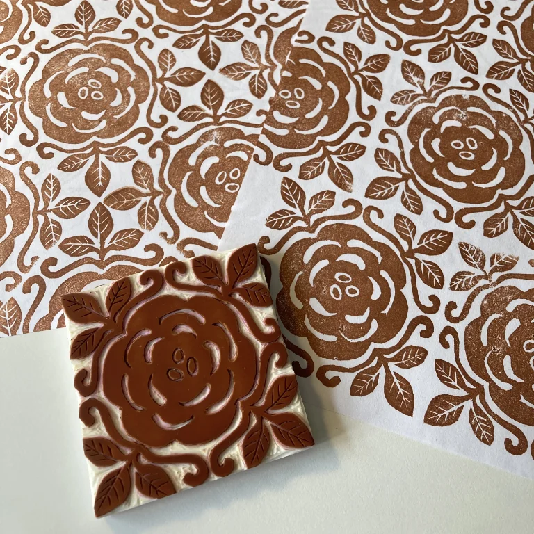 Hand-carved block print with a rose design in sepia brown ink.